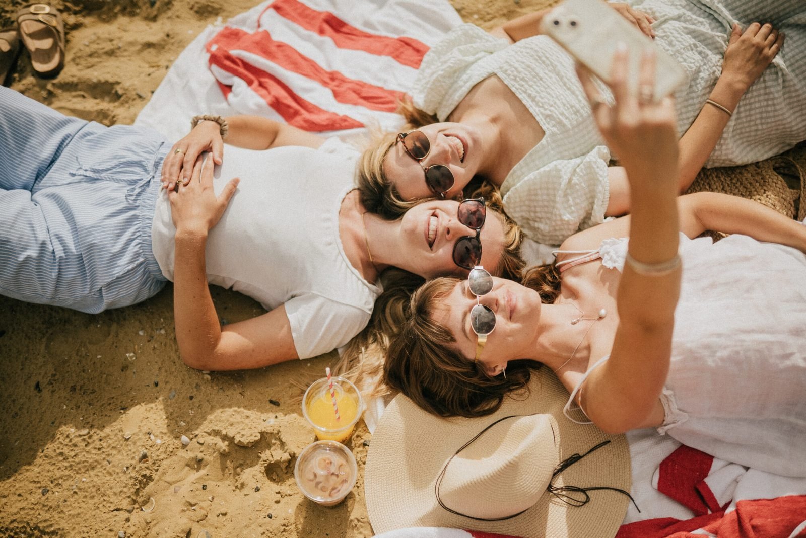 Three friends taking a selfie on the beach, authentic lifestyle stock footage shot on the Isle of Wight by Reuben Mowle